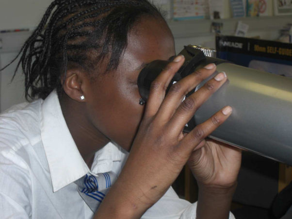 A student looking through a telescope