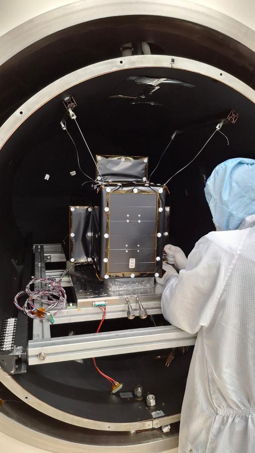 A model of the CosmoCube satellite undergoes thermal vacuum tests at the RAL Space facilities. 