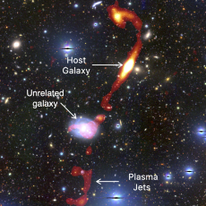 The newly-discovered giant radio galaxy ‘Inkathazo’. The glowing plasma jets, as seen by the MeerKAT telescope, are shown in red and yellow. The starlight from other surrounding galaxies can be seen in the background.